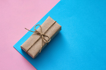 Gender determination day concept. Gift box wrapped in craft paper and tie hemp thread. Pink and blue backgrounds. Girl or boy. Birthday party.	