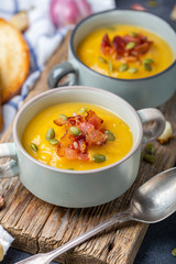 Pumpkin soup with bacon in a rustic style.