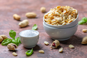 Fried salted peanuts in a white bowl.