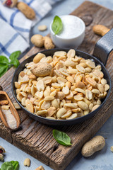 Metal pan with salted peanuts.
