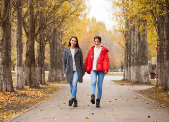 Fototapeta premium Two girlfriends in a gray wool coat and a red down jacket