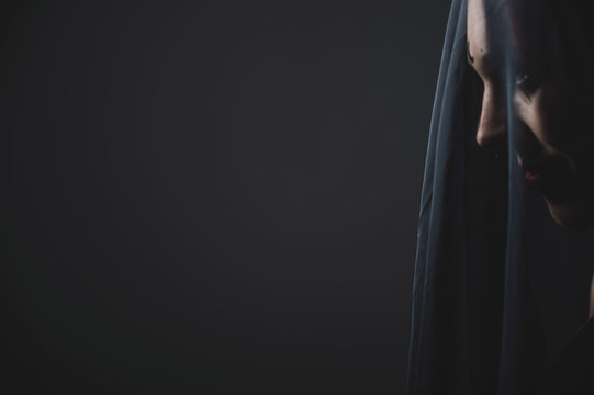 Profile Of A Woman In A Black Veil. Costume Dead Bride For Halloween. Portrait Of An Evil Grinning Witch In Front Of A Coven.