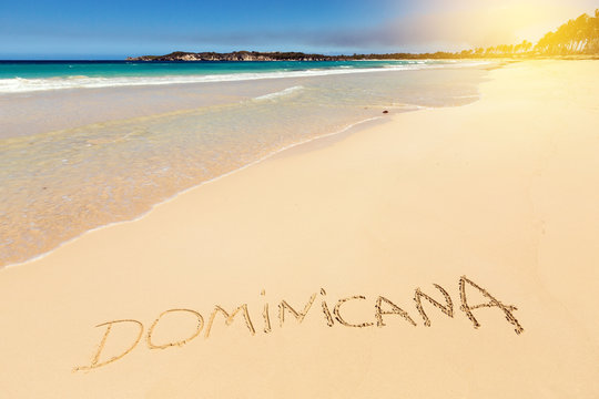 Inscription DOMINICANA on sandy beach