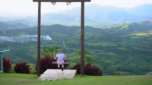 Beautiful view of young woman swing on the top of the mountan Redonda in Dominican Republic. Concept travel, vacation