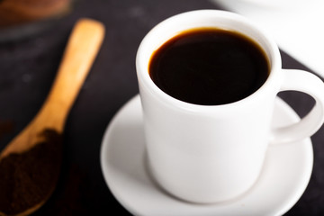 A coffee cup and a spoon spilling coffee powder