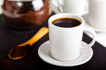 A coffee cup and a spoon spilling coffee powder