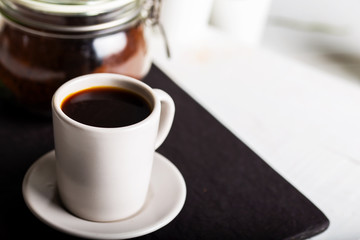 Cup of coffee on wooden background.