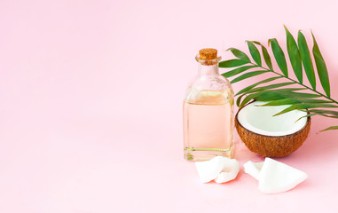 Coconut with coconut oil on pink background. Copy space