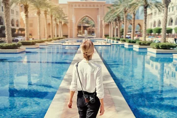 Papier Peint photo Dubai Profiter des voyages aux Emirats Arabes Unis. Jeune femme avec caméra marchant sur le centre-ville de Dubaï.