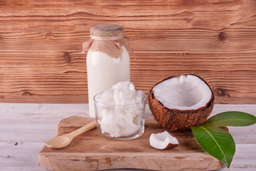Coconut butter and milk on white wooden table . Healthy food concept 
