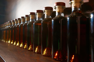 Colour scale gradation of whiskey and cognac infusion in bottles. bottle ranking by age time.