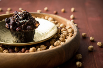 Haselnuss Muffin in Gold Messing Metall und Holz Schale mit Nüsse auf Holz Tisch Hintergrund