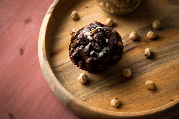 Fototapeta na wymiar Haselnuss Muffin in Schale mit Nüsse auf Holz Tisch Hintergrund