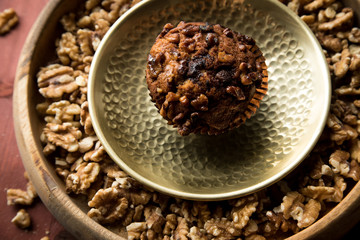 Walnuss Muffin in gold Messing Metall und Holz Schale mit Nüsse auf Holz Tisch Hintergrund
