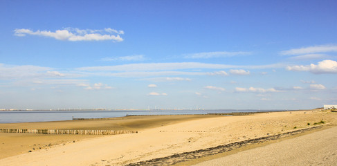 beautiful sand beach along scheldt river in zeeland, holland in springtime with a blue sky