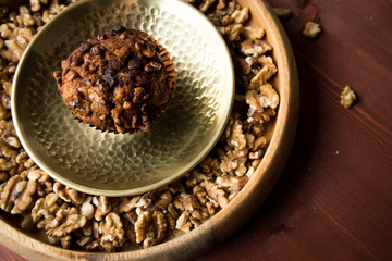 Walnuss Muffin in gold Messing Metall und Holz Schale mit Nüsse auf Holz Tisch Hintergrund