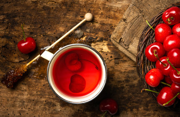 Cherry tea with fruits on a rustic table