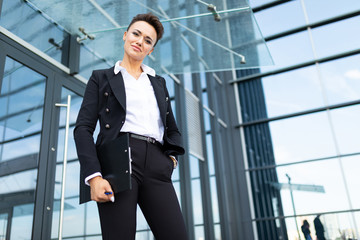 Young beautiful businesswoman posing against modern building