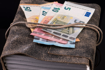 Euro bills and old leather cover book