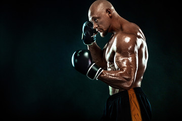 Sportsman, man boxer fighting in gloves on black background. Fitness and boxing concept. Individual...
