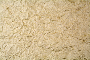 Background from crumpled paper of brown color.