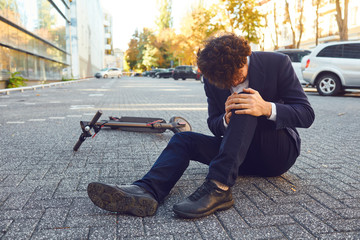 Accident with an electric scooter. A man fell from a scooter on a city street.
