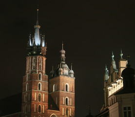 Fototapeta na wymiar Torres de la Basílica de Santa María en Cracovia, iluminadas en la noche (Polonia).