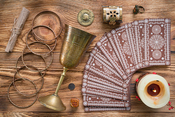 Tarot cards and golden goblet on brown table of fortune teller. Divination. Future reading concept.