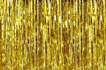 Christmas decoration. Background from golden shiny tinsel closeup.