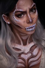 White skull on poster for Halloween party with creative make-up or in style Dia De Los Muertos holiday on dark background with copyspace. Blonde Model, close up in studio.