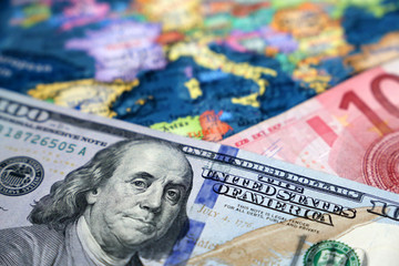 US dollar and Euro banknotes on the map of Europe. Concept of exchange rate, investment and trade between the United States and European Union
