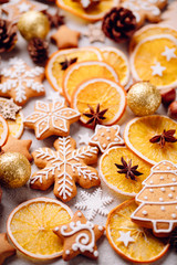 Christmas and New Year composition. Festive decorations in gold colors and homemade gingerbread on stone background. Holiday and celebration concept