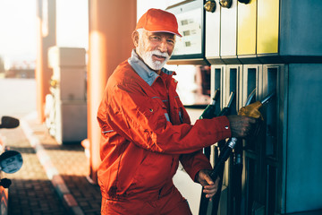 Handsome senior with beard man working on gas station