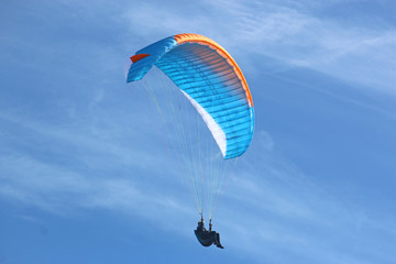 Paraglider flying wing in a blue sky