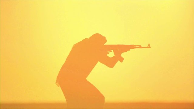 warrior with Kalashnikov at sunset day. fighter is training with a machine gun at sunset.