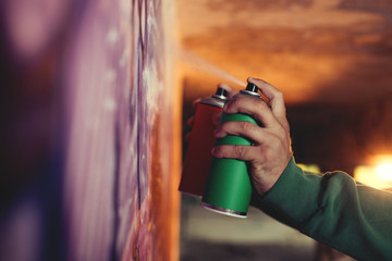 Street artist holding spray paint can, close up