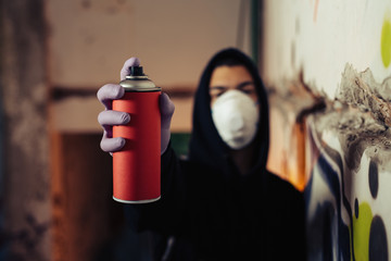 Graffiti artist pointing the spray to camera