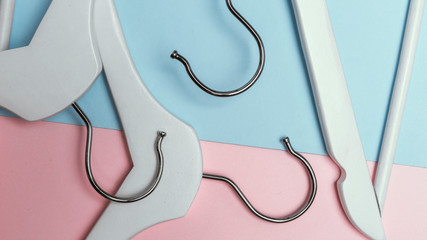 Heap of colorful clothes hangers on blue-pink background. Space for texts. Flat lay. Hangers hook close up