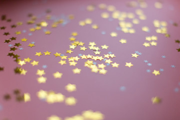 Stars and snowflakes on a pink background, from above