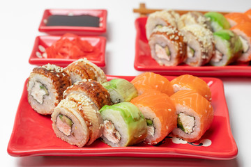delicious sushi and rolls on a red plate on a white background. traditional Japanese cuisine