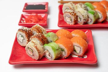 delicious sushi and rolls on a red plate on a white background. traditional Japanese cuisine