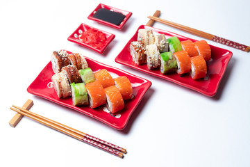delicious sushi and rolls on a red plate on a white background. traditional Japanese cuisine