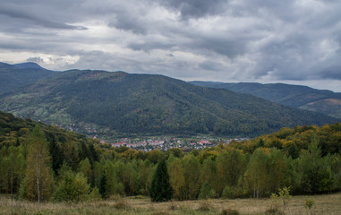 Mountain forest green landscape with houses and a far village.