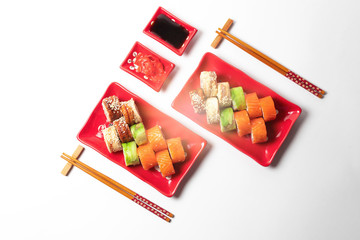 delicious sushi and rolls on a red plate on a white background. traditional Japanese cuisine