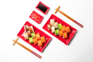 delicious sushi and rolls on a red plate on a white background. traditional Japanese cuisine
