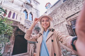 Fototapeta premium Tourism and technology. Traveling young woman taking selfie at Split old Town, Croatia.