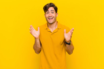  looking happy and excited, shocked with an unexpected surprise with both hands open next to face