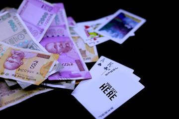 playing poker, playing cards with Indian Rupee Banknotes on black background