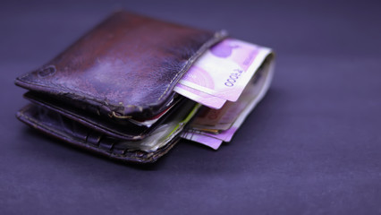 men's purse with Indian currency note inside on the black background