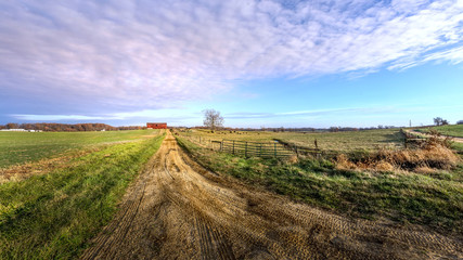 Rural Maryland Farm Landscape with long Dirt Road leading to a Red Barn